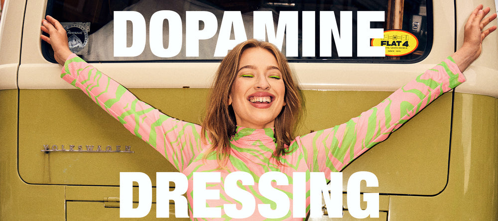 kvinde i farverigt tøj med armene ud til hver side og titlen "Dopamine Dressing"